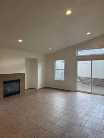 an empty room with windows and fireplace