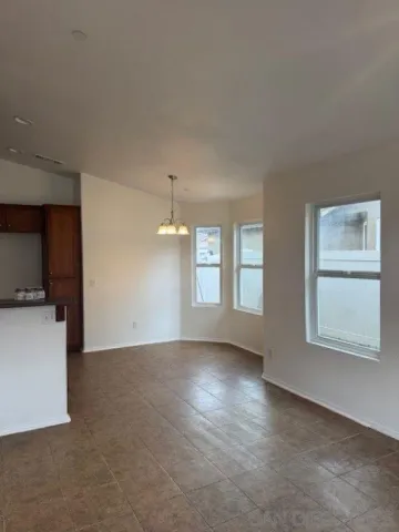 an empty room with windows and chandelier