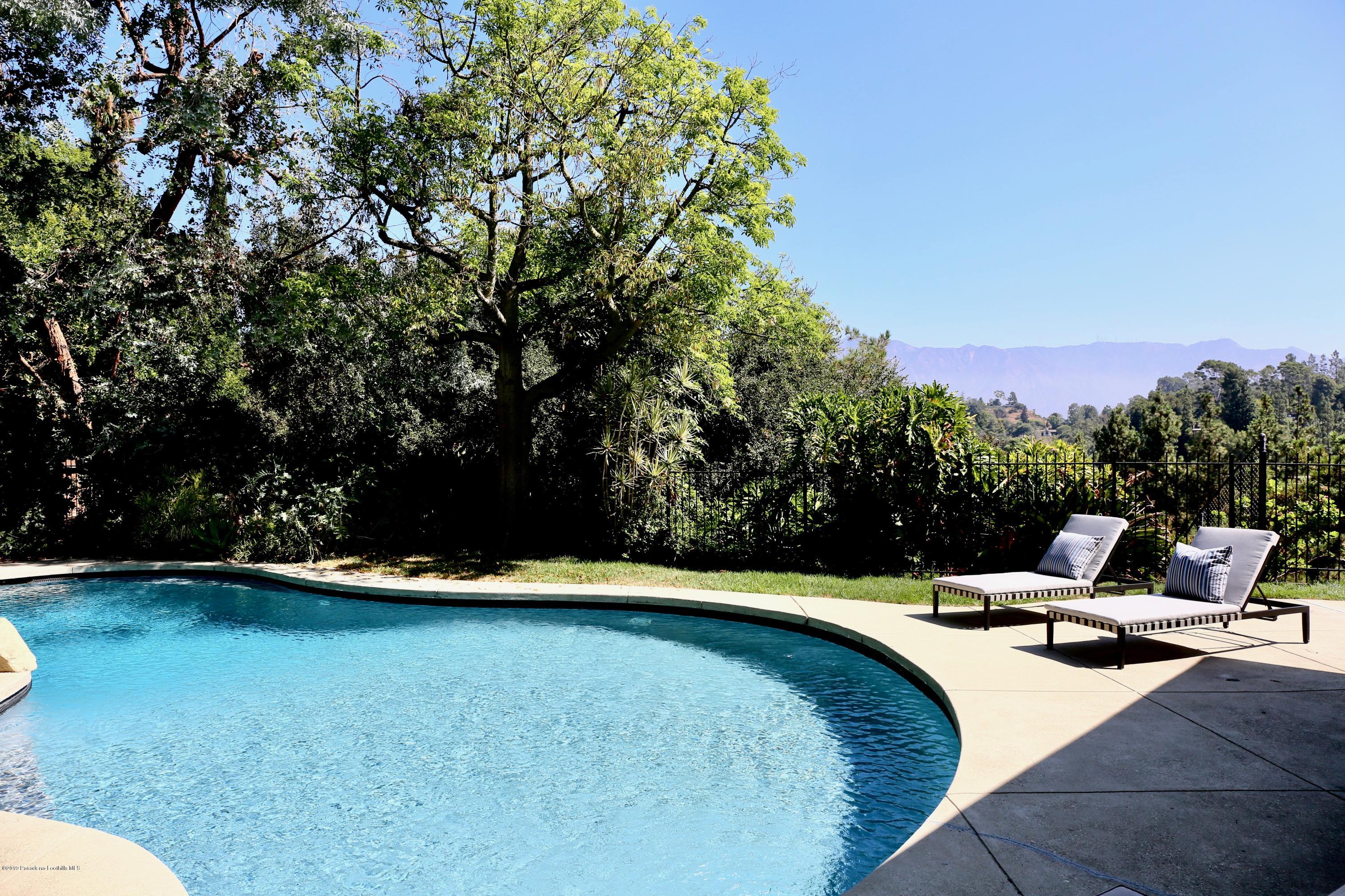 250 La Mirada Road Pasadena, CA 91105 - Photo 22 of 42 a view of swimming pool with lawn chairs and wooden fence