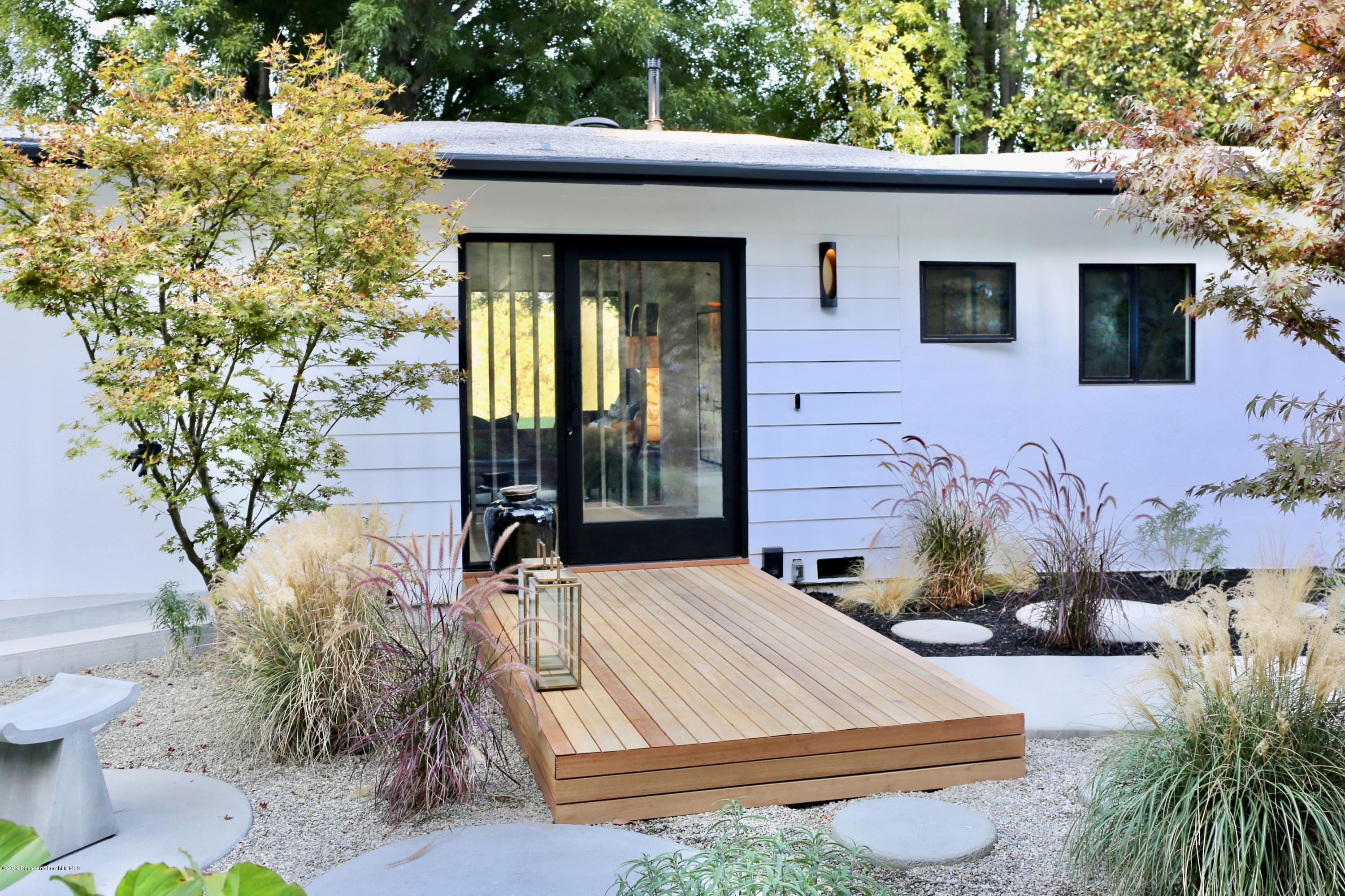 250 La Mirada Road Pasadena, CA 91105 - Photo 5 of 42 a view of a white house with a large window and potted plants