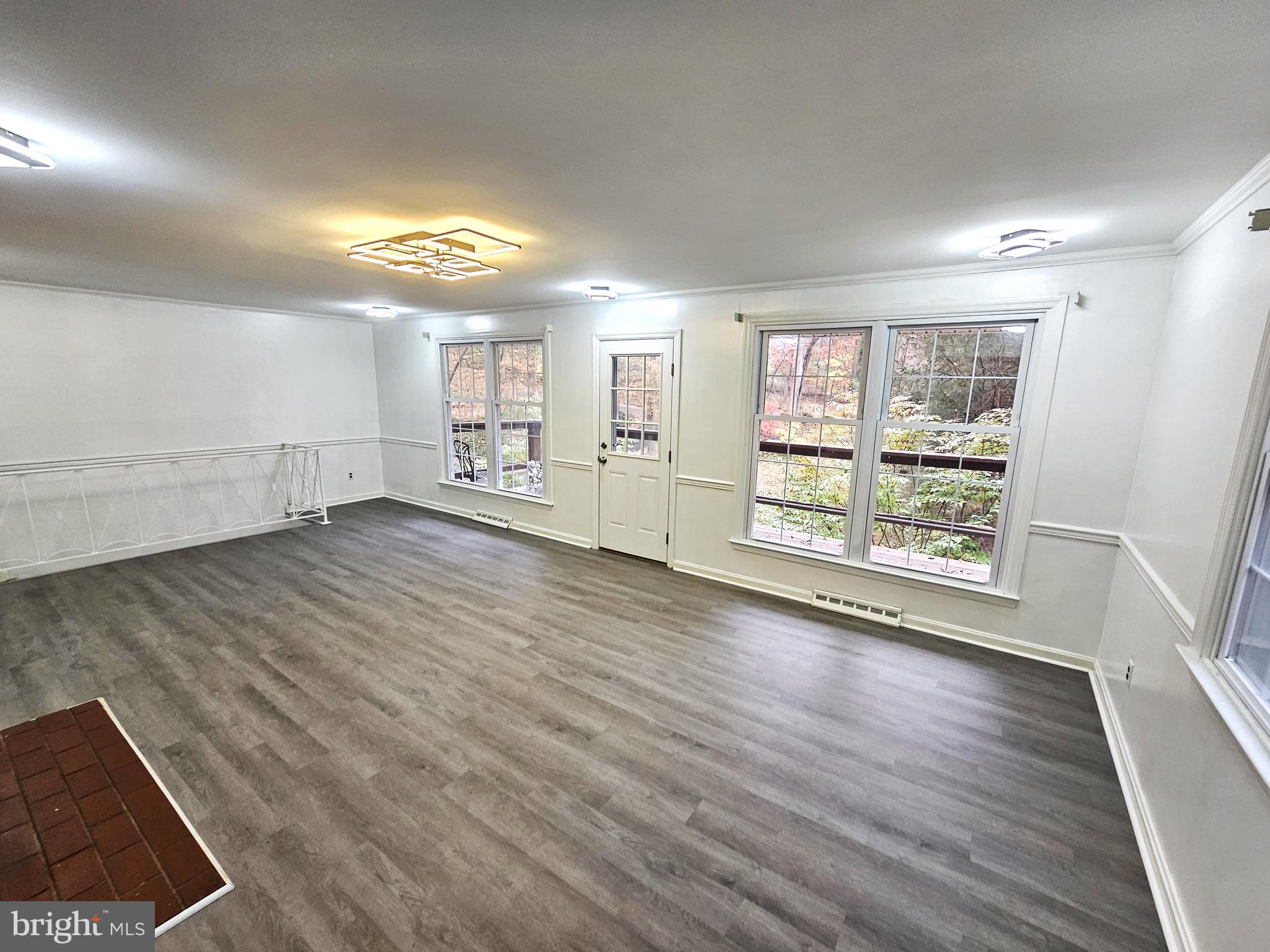 757 Auburn Mill Road Hockessin, DE 19707 - Photo 4 of 10 an empty room with wooden floor and windows