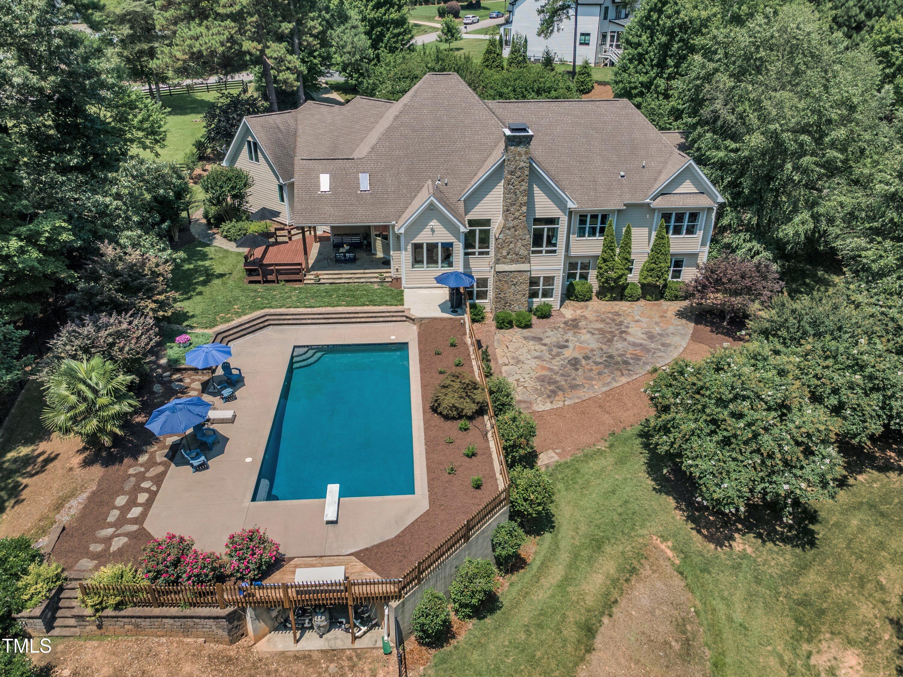 an aerial view of a house with swimming pool and yard