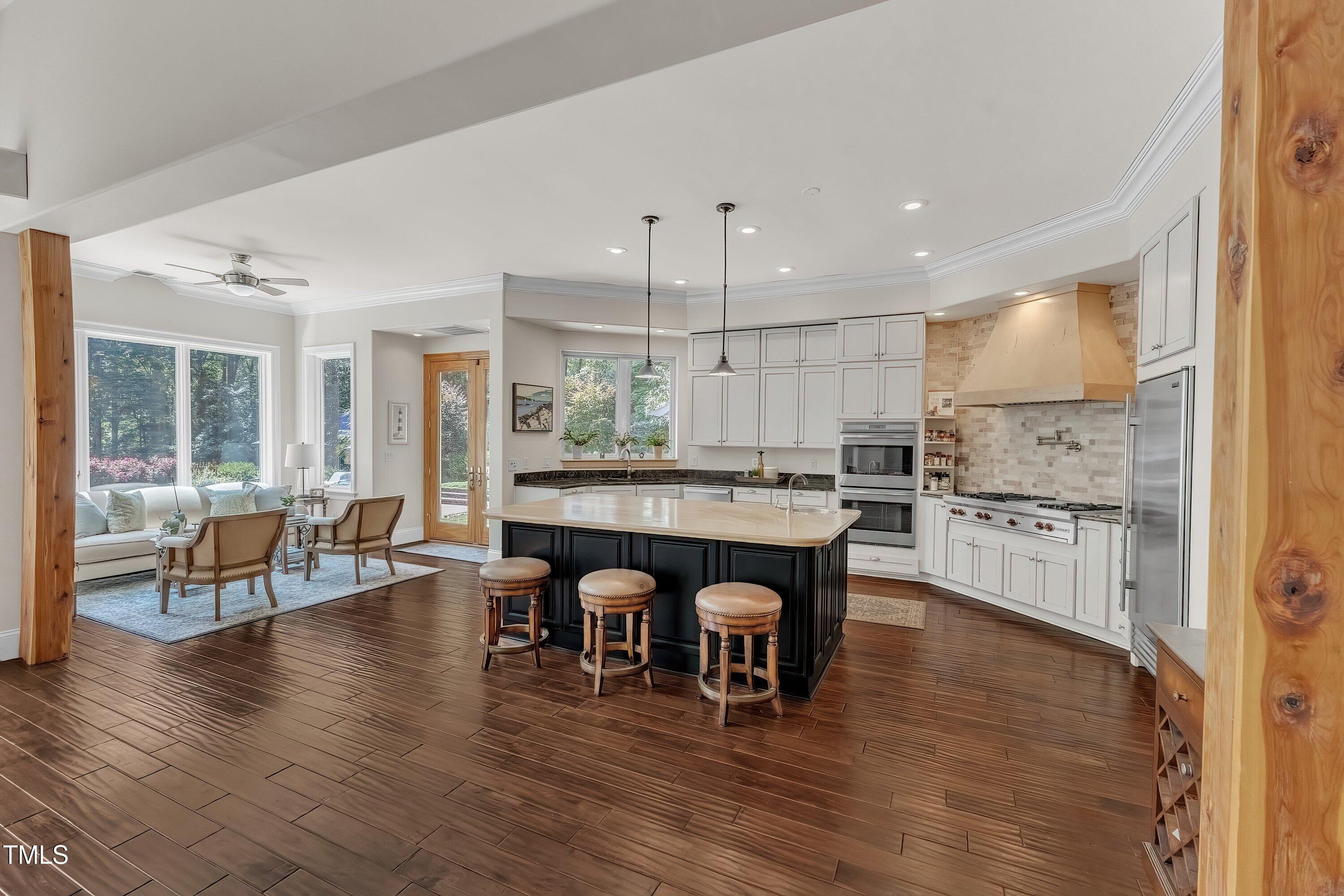 1004 Tobiano Lane Raleigh, NC 27614 - Photo 12 of 48 a kitchen with stainless steel appliances granite countertop a stove a refrigerator a kitchen island a dining table and chairs with wooden floor