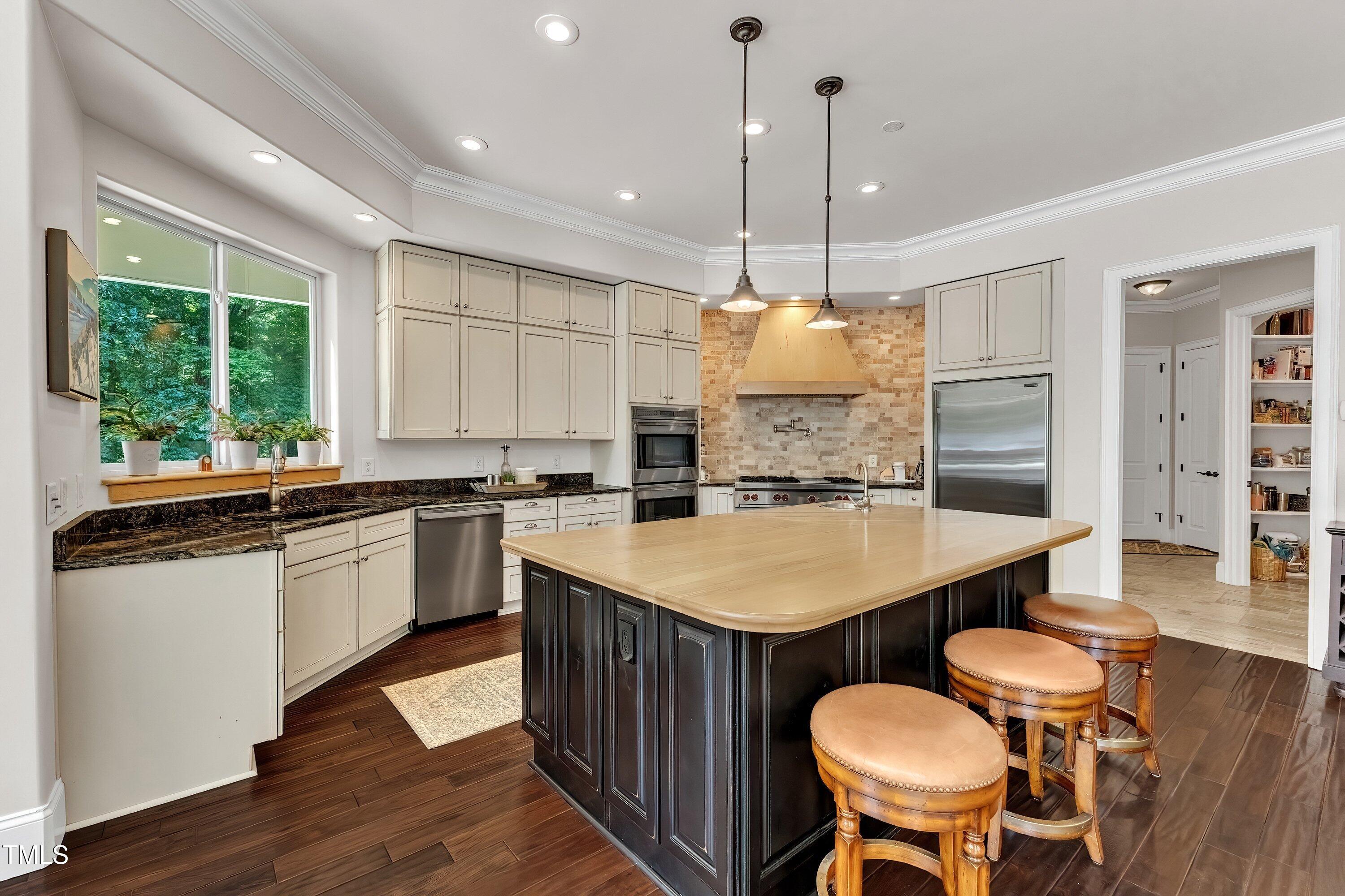 1004 Tobiano Lane Raleigh, NC 27614 - Photo 13 of 48 a kitchen with a table chairs stove and wooden floor