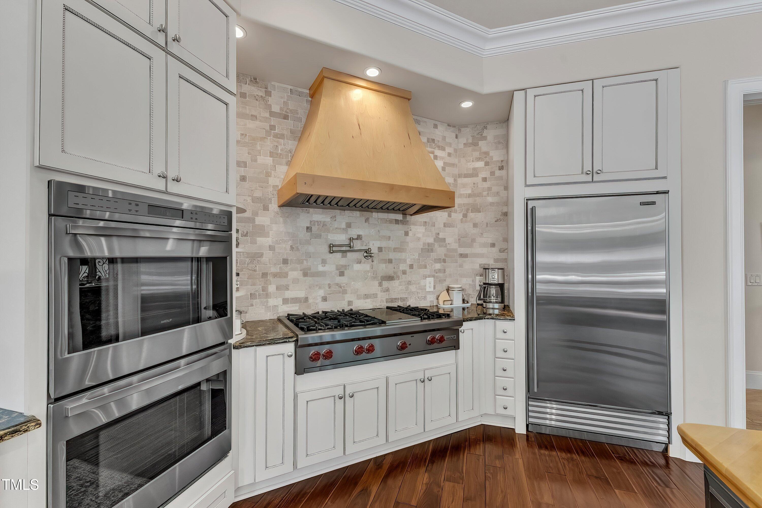 1004 Tobiano Lane Raleigh, NC 27614 - Photo 15 of 48 a kitchen with white cabinets and appliances