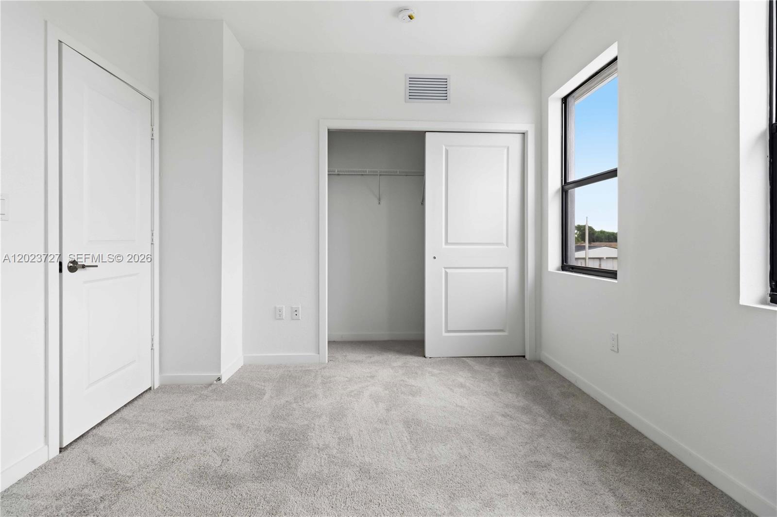 22348 Southwest 115th Court, Unit 22348 Miami, FL 33170 - Photo 13 of 37 an empty room with windows and closet