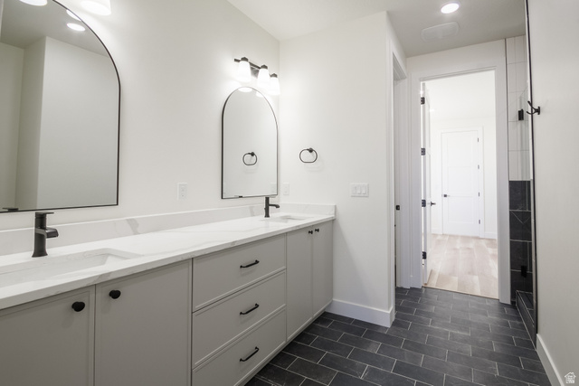 3322 250 S Street Vernal, UT 84078 - Photo 15 of 37 Bathroom featuring a double vanity with light gray cabinetry, white countertops, black fixtures, and arched mirrors