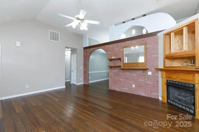 a view of a hallway with wooden floor and a fireplace