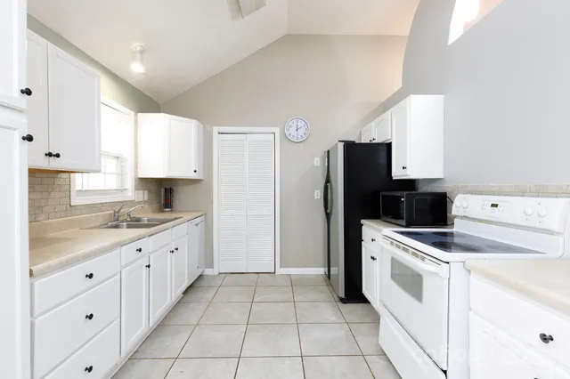 a kitchen with a stove top oven sink and refrigerator