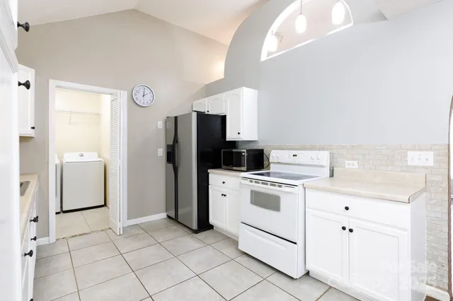 a kitchen with white cabinets and white appliances