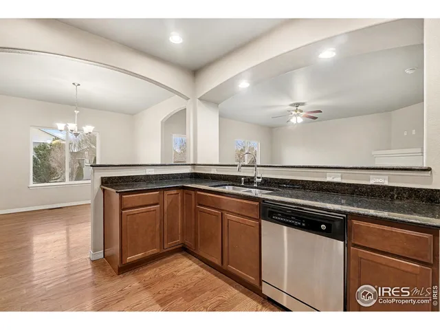 a view of an empty room with chandelier fan and fire place