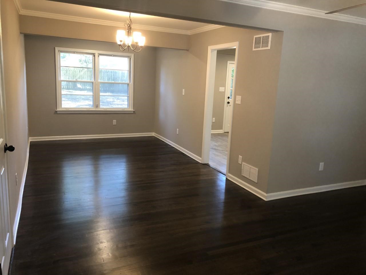 1154 West Perkins Road Memphis, TN 38117 - Photo 3 of 7 an empty room with wooden floor and windows