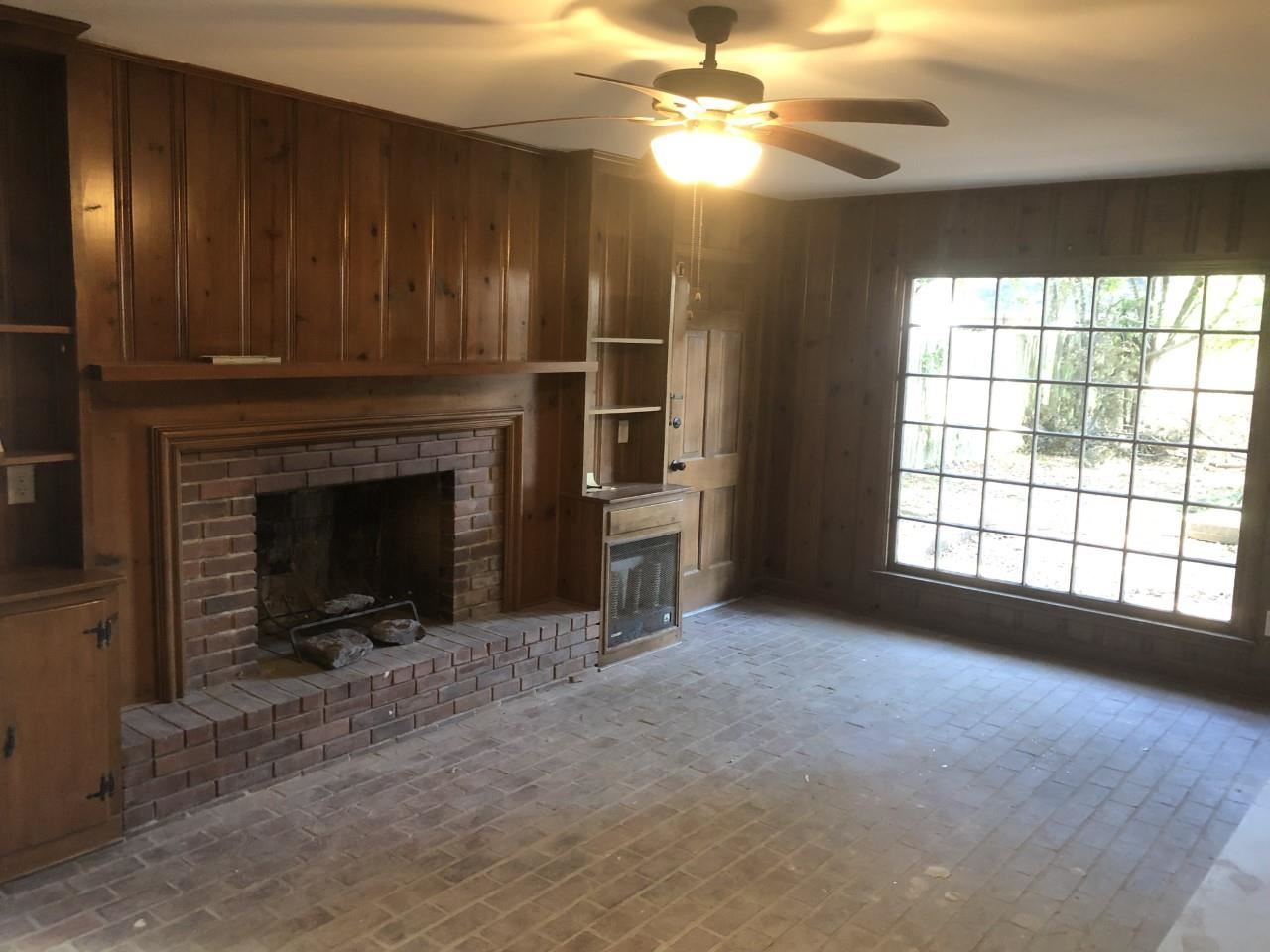 1154 West Perkins Road Memphis, TN 38117 - Photo 4 of 7 a view of an empty room with a fireplace and a window