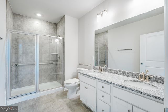 a bathroom with a granite countertop sink toilet mirror and shower