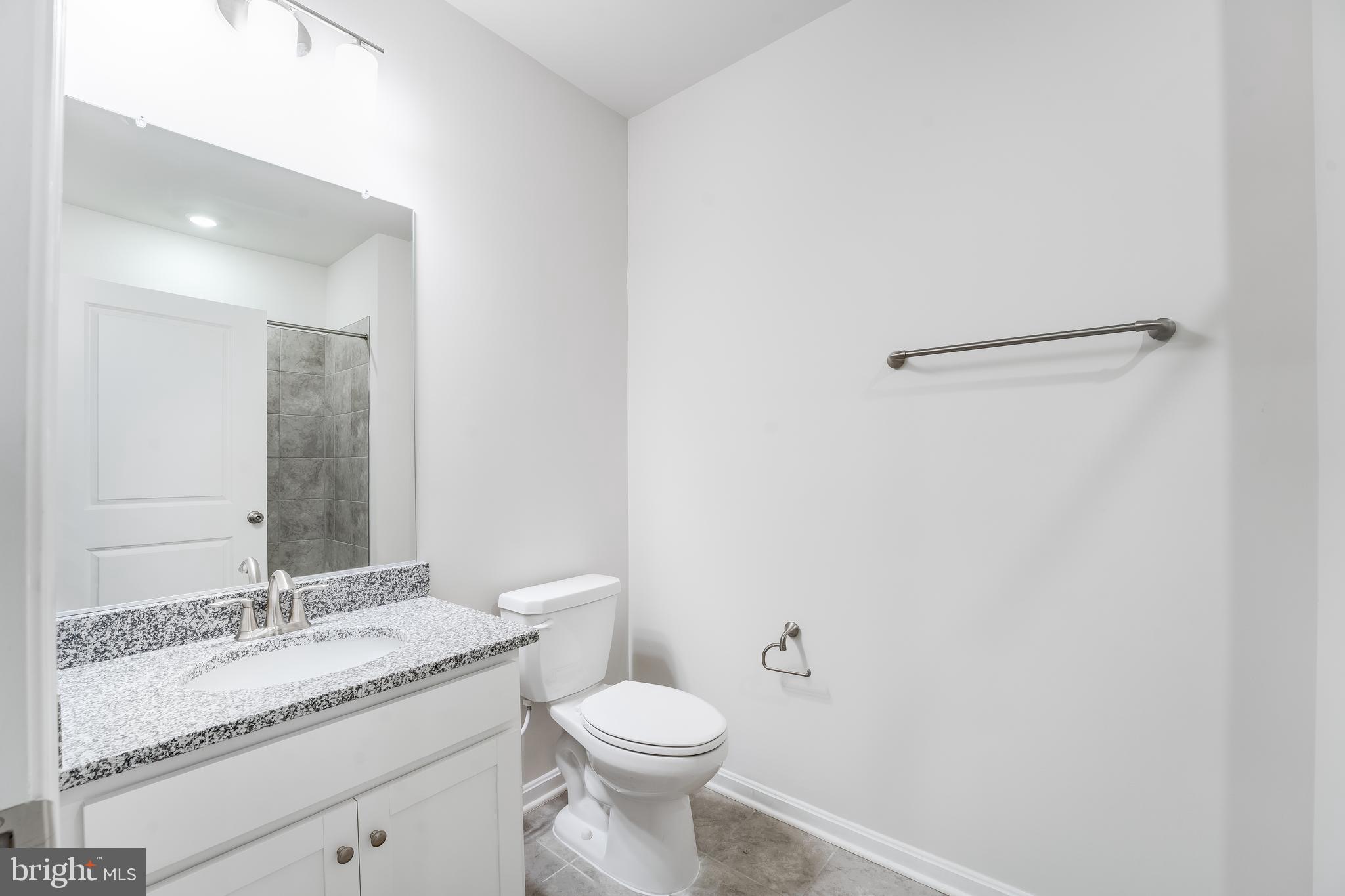 4003 Seaside Alder Road, Unit 208 ROSE Bowie, MD 20720 - Photo 5 of 18 a bathroom with a granite countertop sink toilet and mirror
