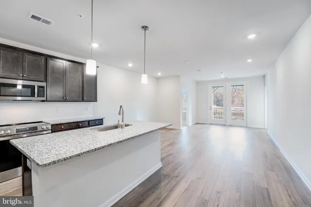 a bathroom with a granite countertop sink and a refrigerator
