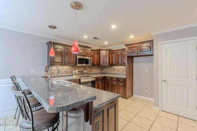 a kitchen with stainless steel appliances granite countertop a stove top oven sink and cabinets