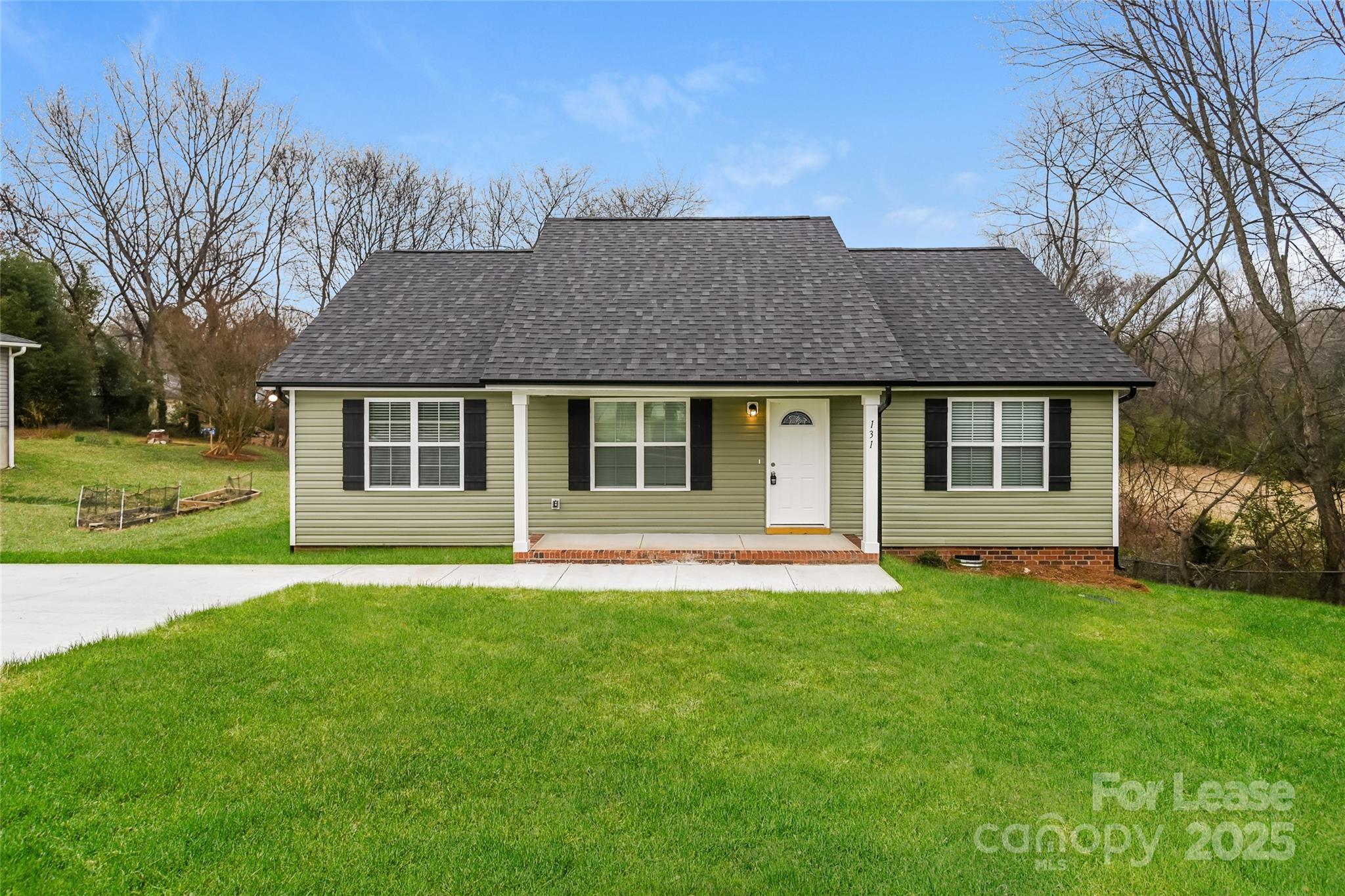 131 Powder Street Southwest Concord, NC 28025 - Photo 1 of 14 a front view of a house with a garden