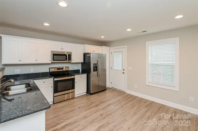 a kitchen with stove cabinets and refrigerator