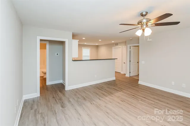 a view of a livingroom with a ceiling fan and wooden floor