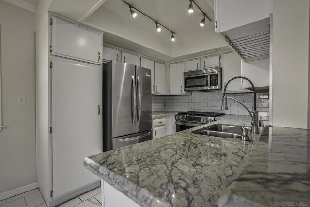 a kitchen with granite countertop a refrigerator and a sink