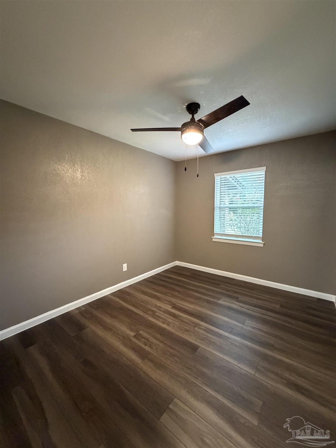 932 Fremont Avenue Pensacola, FL 32505 - Photo 13 of 16 an empty room with wooden floor and windows