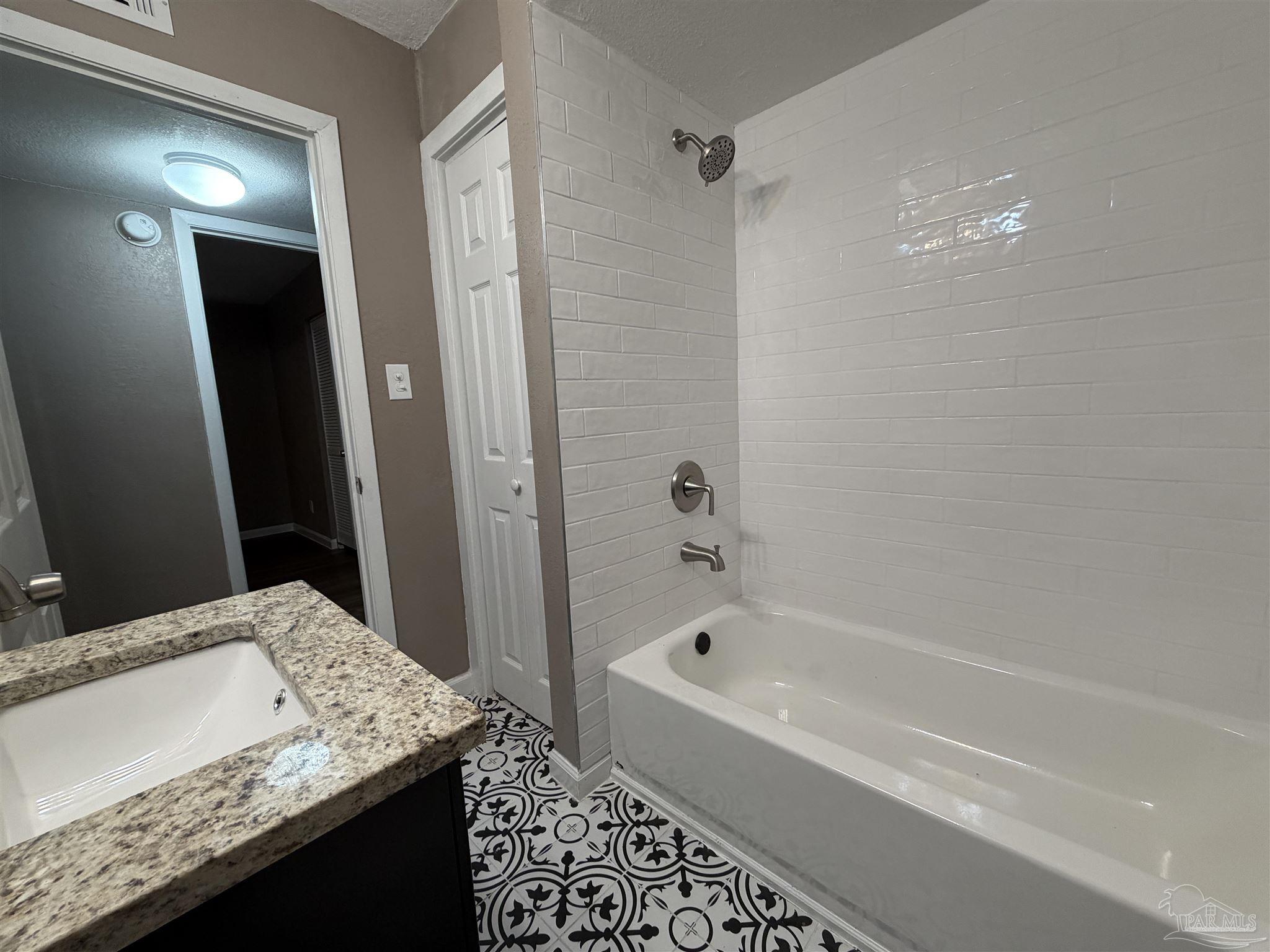 932 Fremont Avenue Pensacola, FL 32505 - Photo 15 of 16 a bathroom with a granite countertop sink a shower and a mirror