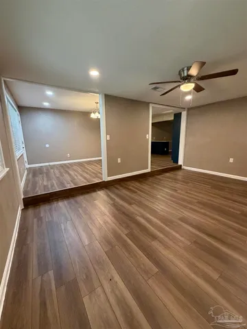 a view of a room with wooden floor