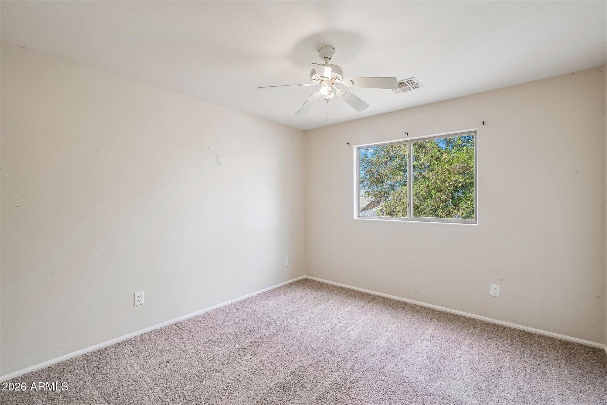 3903 East Citrine Road San Tan Valley, AZ 85143 - Photo 19 of 34 an empty room with a chandelier fan and windows