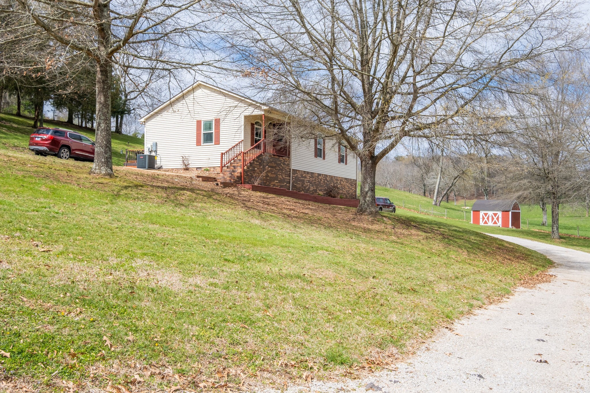 1303 John Sharp Road Columbia, TN 38401 - Photo 3 of 53 a view of a white house next to a yard and a large tree