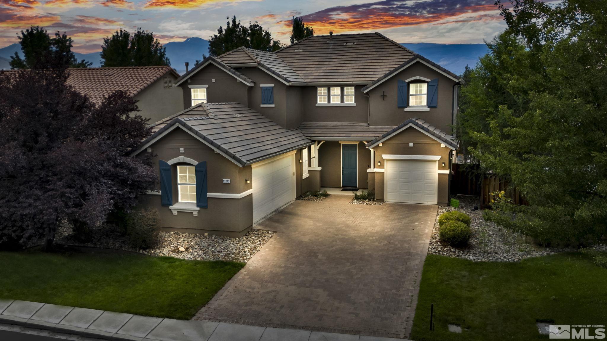 a front view of a house with a yard and trees