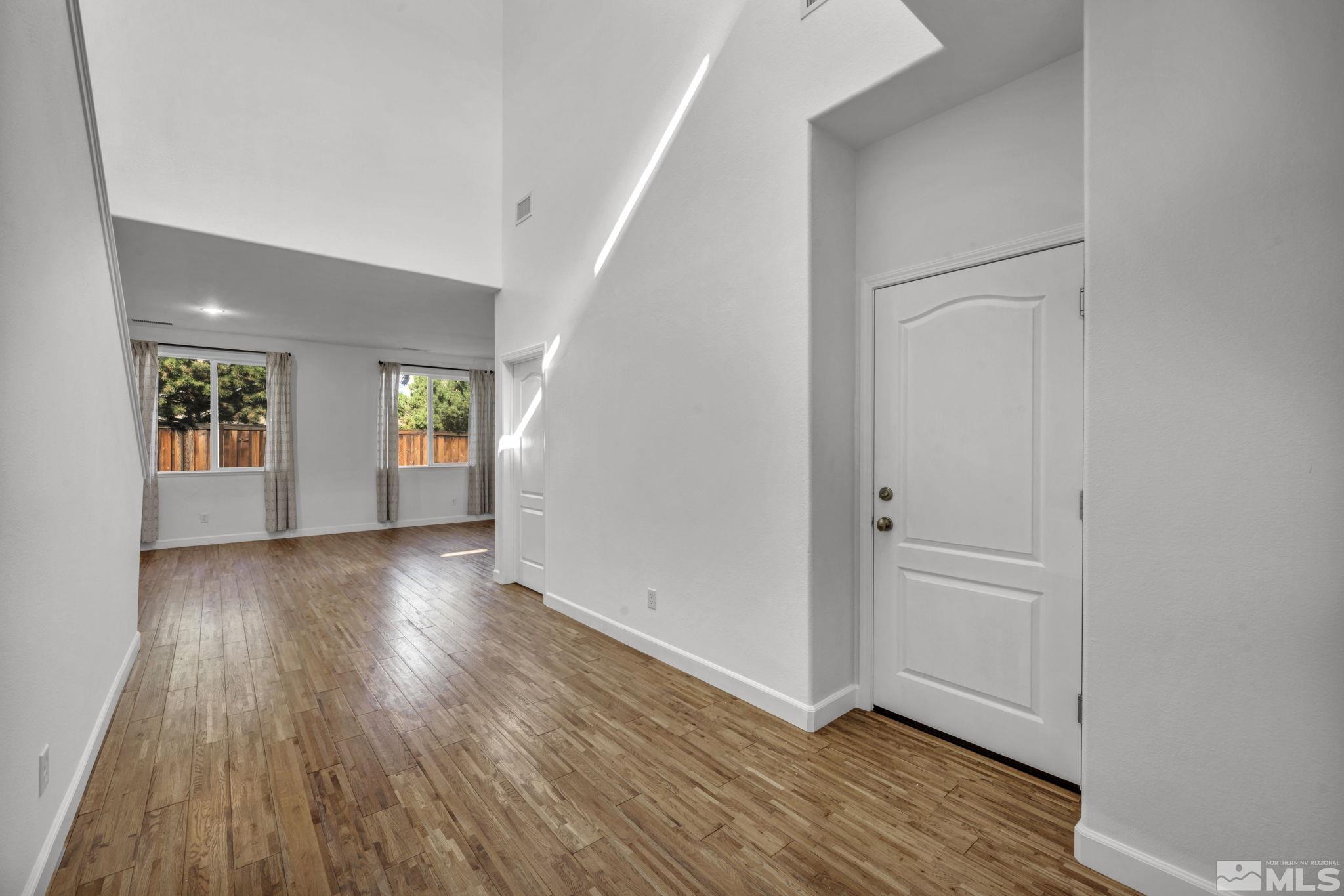 11275 Torino Way Reno, NV 89521 - Photo 11 of 37 an empty room with wooden floor and windows