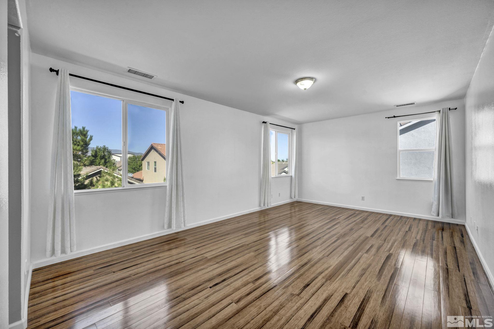 11275 Torino Way Reno, NV 89521 - Photo 17 of 37 a view of empty room with wooden floor and fan