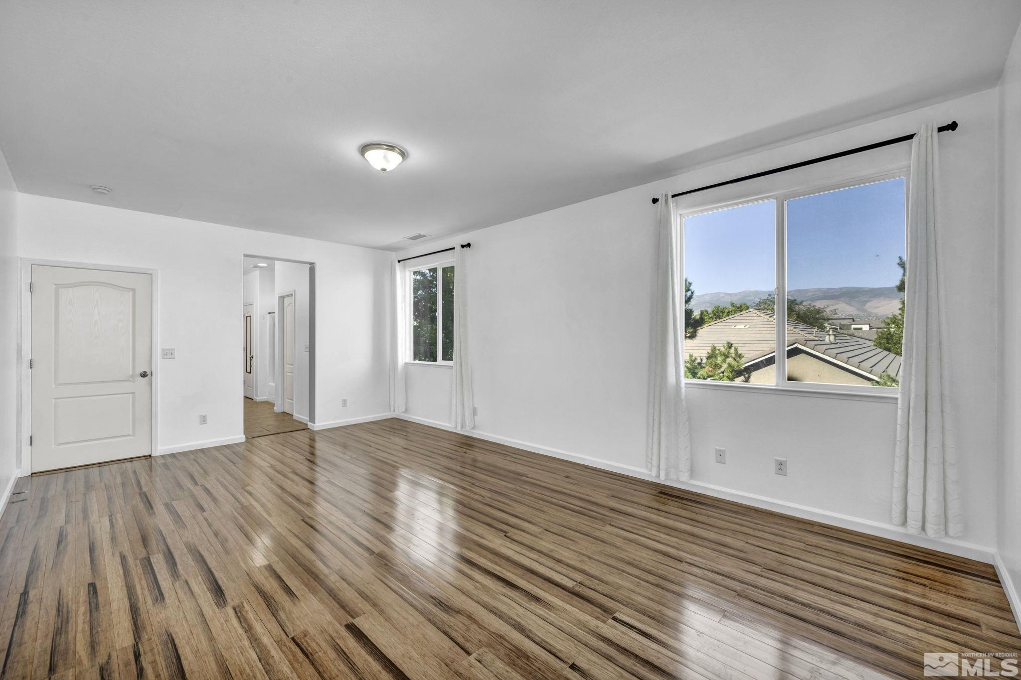 11275 Torino Way Reno, NV 89521 - Photo 18 of 37 a view of an empty room with wooden floor and a window