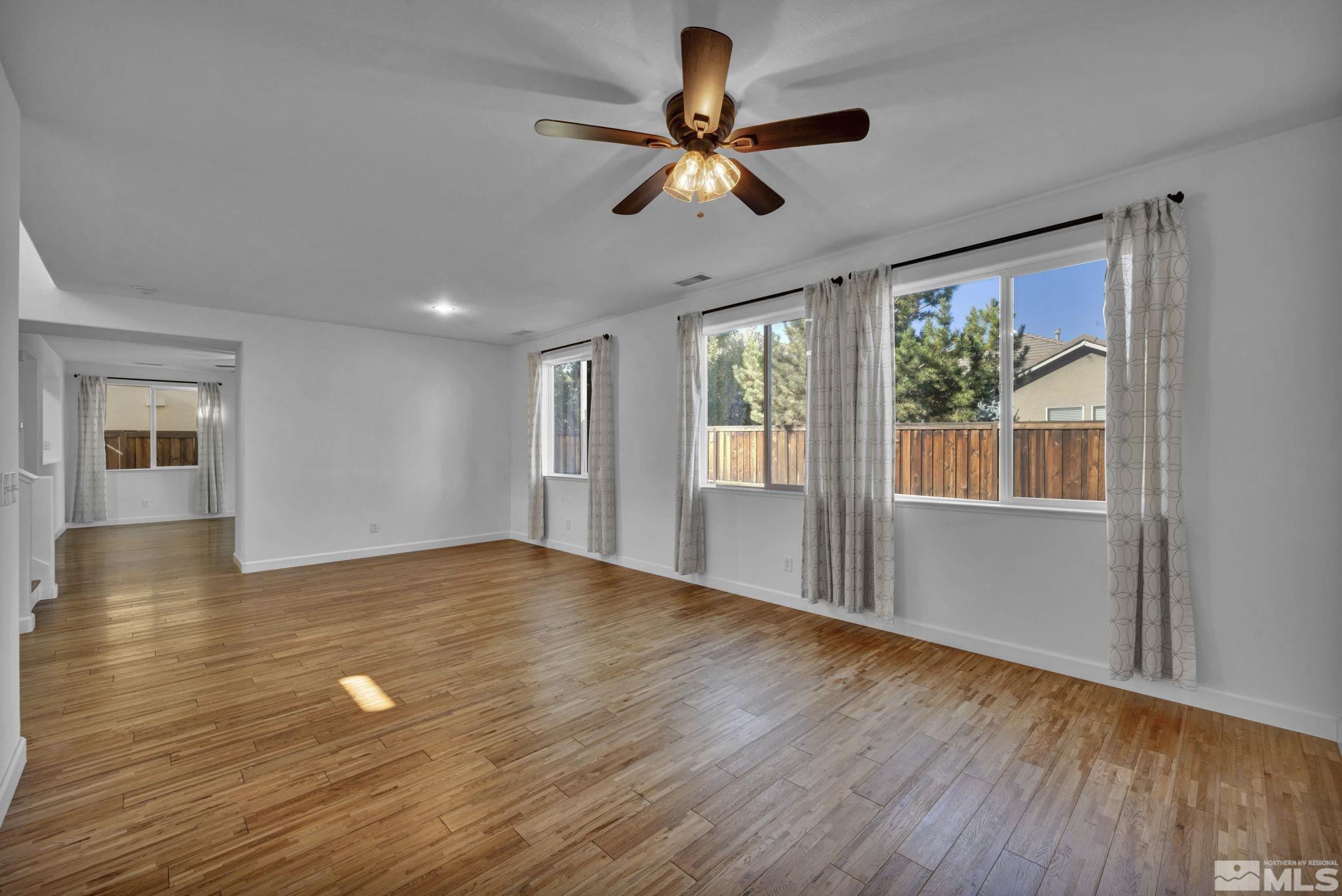 11275 Torino Way Reno, NV 89521 - Photo 7 of 37 a view of empty room with wooden floor and fan