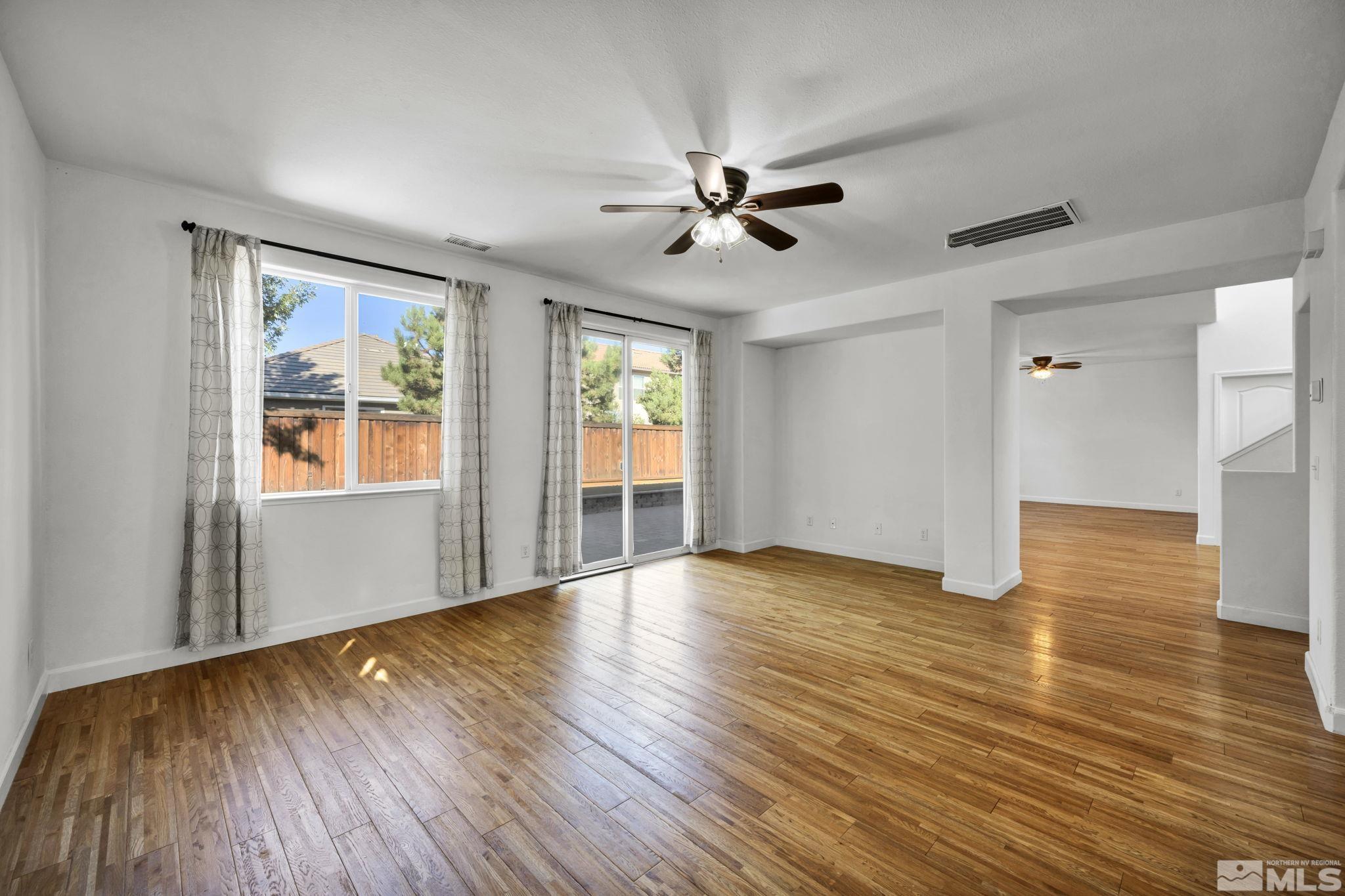 11275 Torino Way Reno, NV 89521 - Photo 8 of 37 a view of an empty room with wooden floor and a window