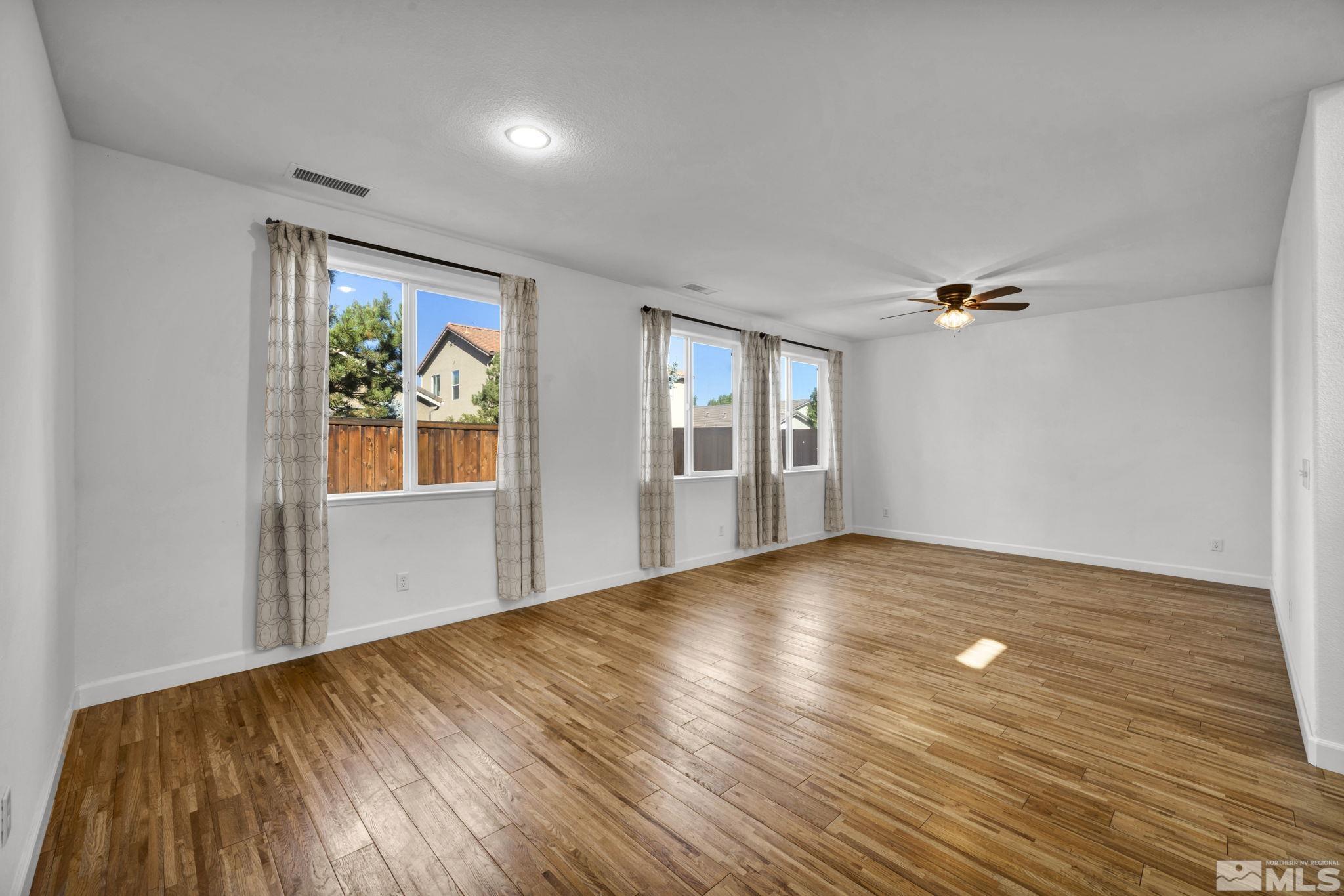 11275 Torino Way Reno, NV 89521 - Photo 9 of 37 a view of empty room with wooden floor and fan