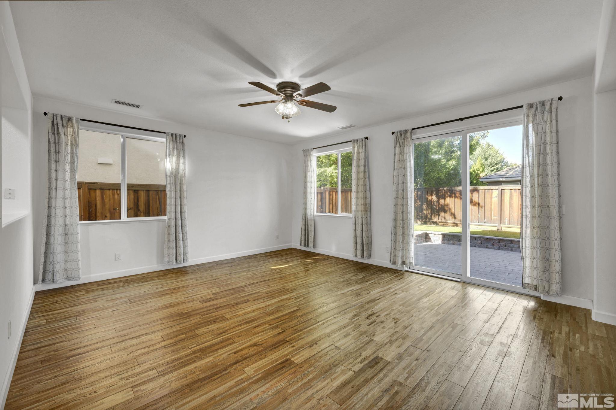 11275 Torino Way Reno, NV 89521 - Photo 10 of 37 a view of an empty room with a window and wooden floor