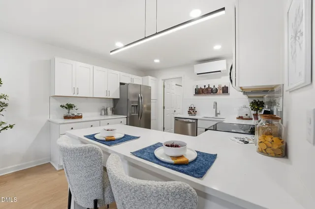 a kitchen with white cabinets and appliances