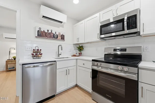 a kitchen with stainless steel appliances a stove a microwave sink and cabinets
