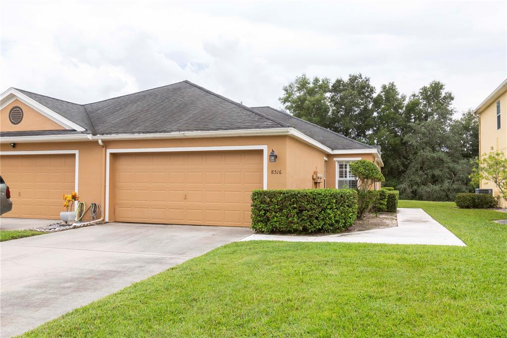 8516 Corinthian Way New Port Richey, FL 34654 - Photo 1 of 1 a front view of a house with a garden and yard