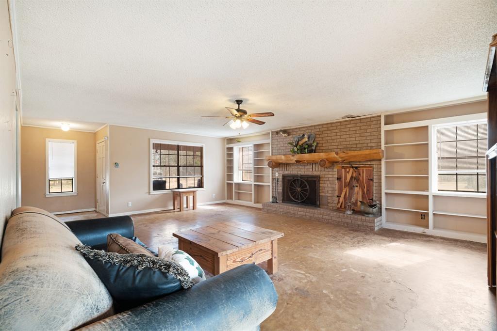 595 County Road Powderly, TX 75473 - Photo 3 of 25 a spacious bedroom with a bed and a fireplace