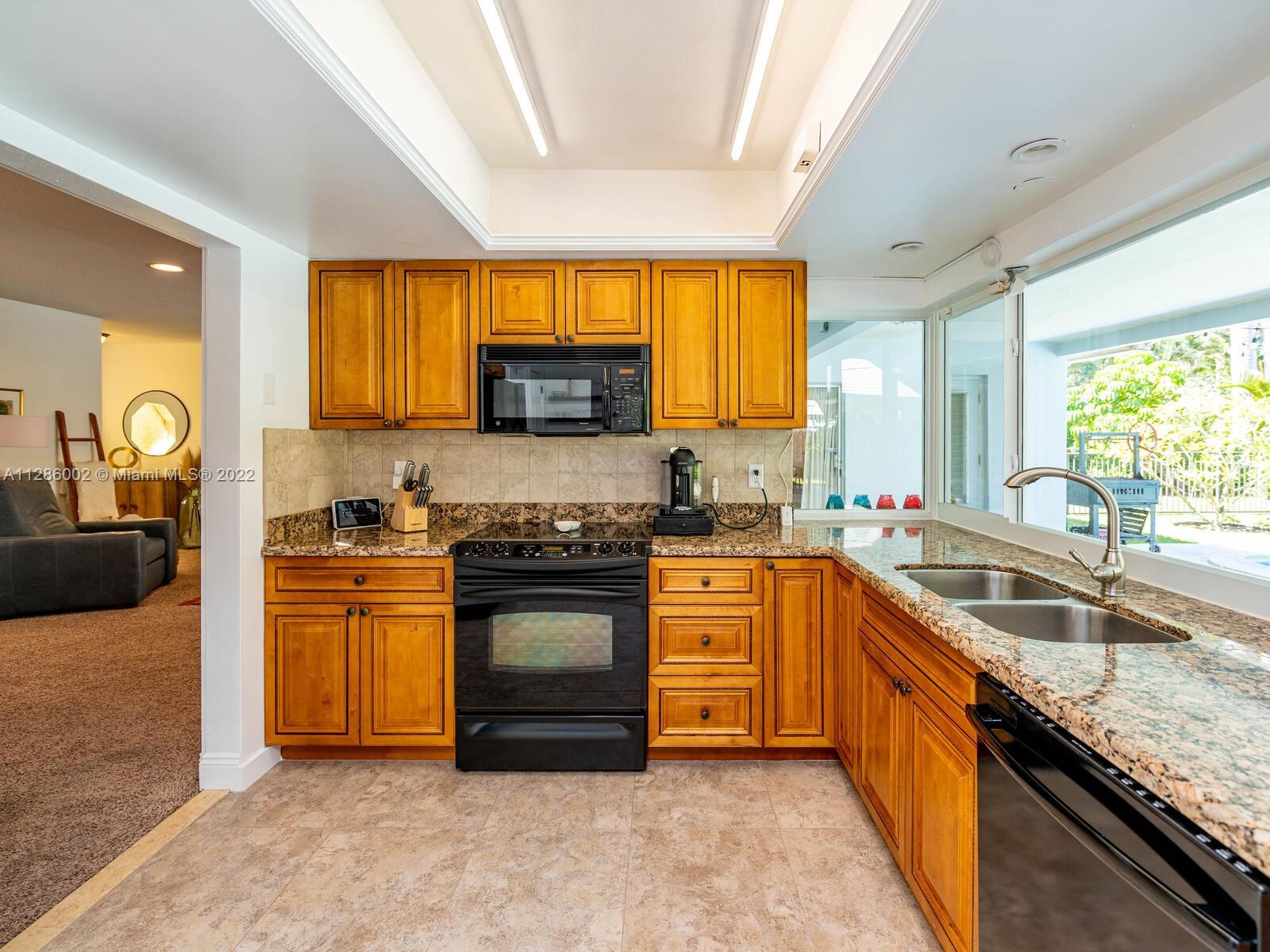 799 Periwinkle Street Boca Raton, FL 33486 - Photo 26 of 55 a kitchen with stainless steel appliances granite countertop a stove a sink and a refrigerator