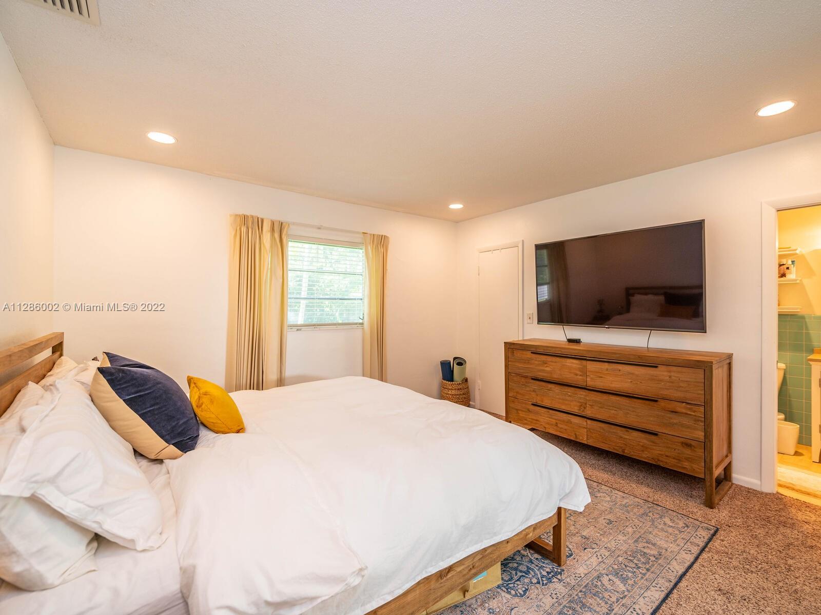 799 Periwinkle Street Boca Raton, FL 33486 - Photo 29 of 55 a bedroom with a bed and flat screen tv