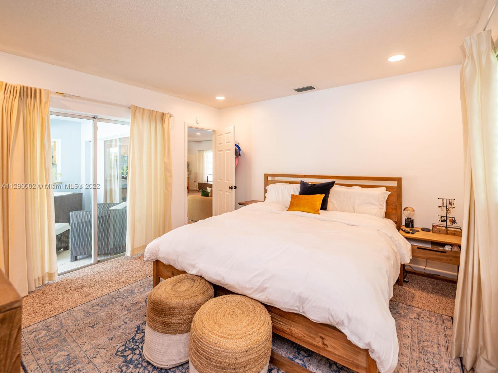 799 Periwinkle Street Boca Raton, FL 33486 - Photo 31 of 55 a bedroom with a bed and wooden floor