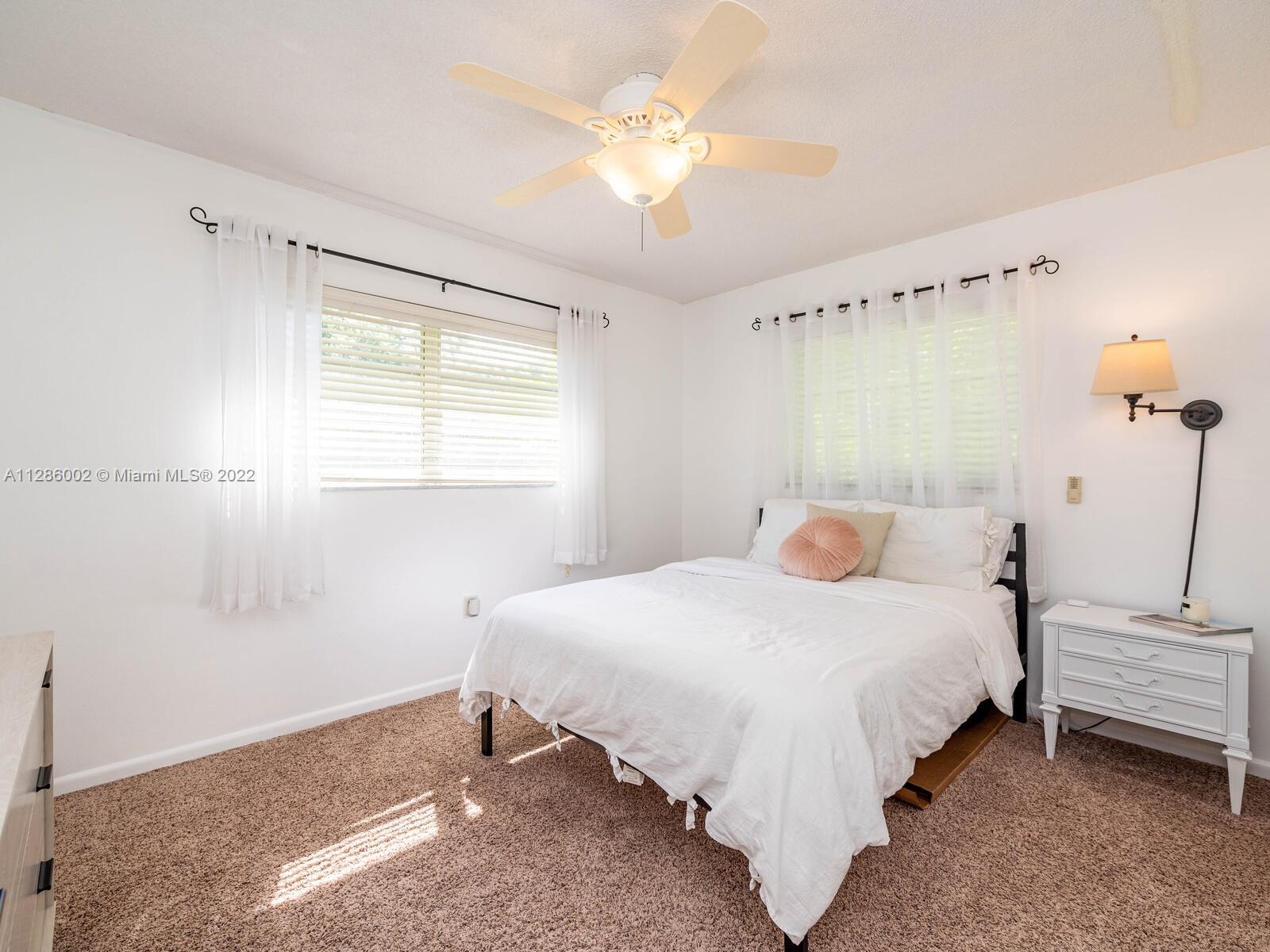 799 Periwinkle Street Boca Raton, FL 33486 - Photo 35 of 55 a bedroom with a bed and a chandelier