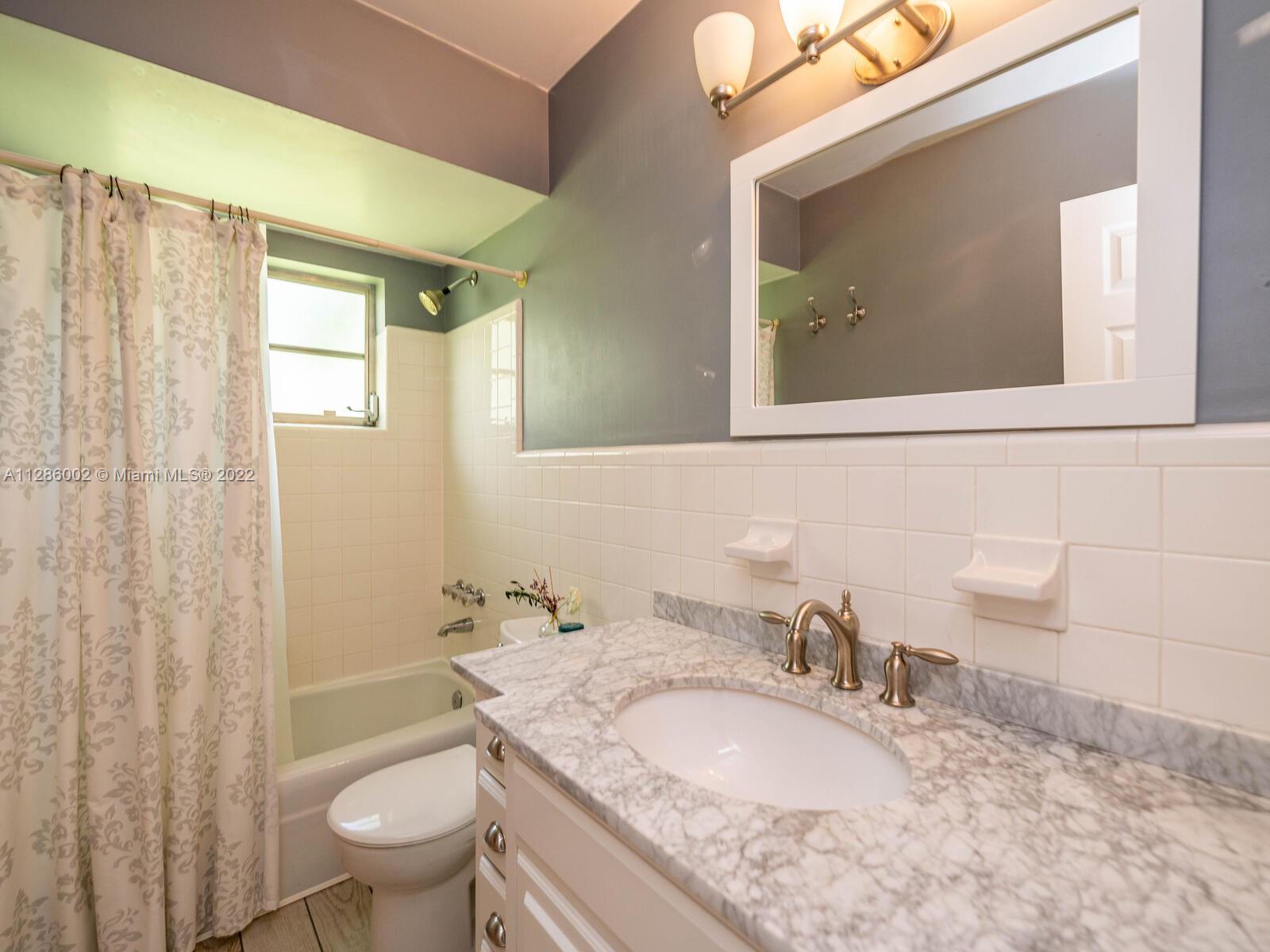 799 Periwinkle Street Boca Raton, FL 33486 - Photo 37 of 55 a bathroom with a granite countertop sink toilet and shower