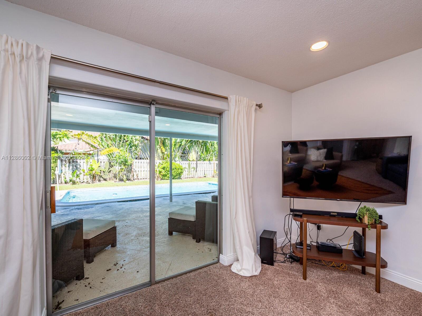 799 Periwinkle Street Boca Raton, FL 33486 - Photo 41 of 55 a living room with furniture and a flat screen tv
