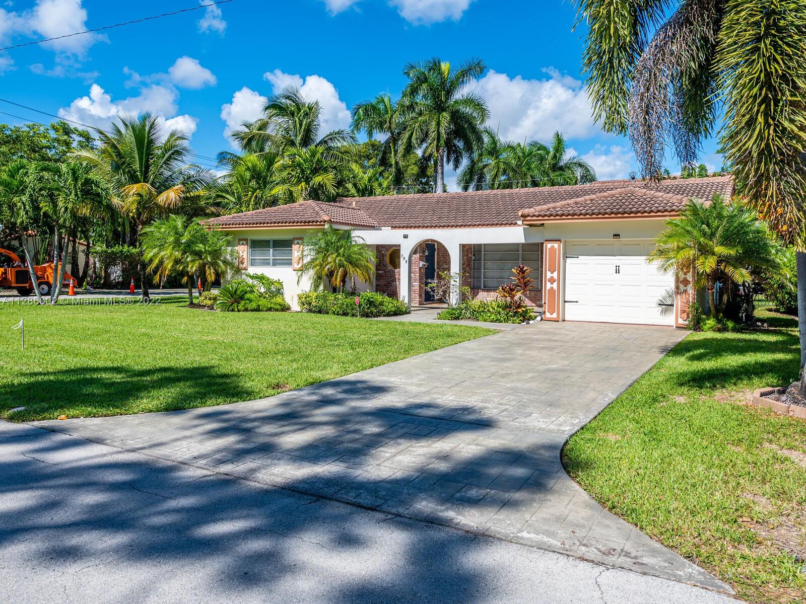 799 Periwinkle Street Boca Raton, FL 33486 - Photo 9 of 55 a front view of a house with a yard and potted plants