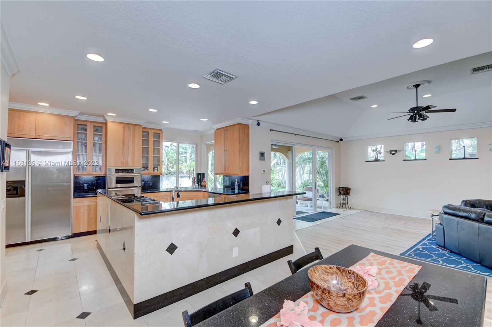18 South River Road Sewall's Point, FL 34996 - Photo 11 of 34 a kitchen with stainless steel appliances kitchen island granite countertop a sink and cabinets
